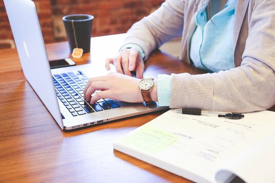 Hands on the laptop of a computer